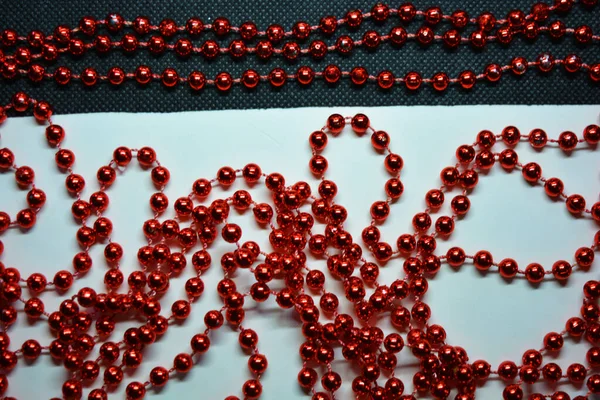 新年和圣诞节的红珠被随意地分散在白色和黑色面料的背景上 — 图库照片