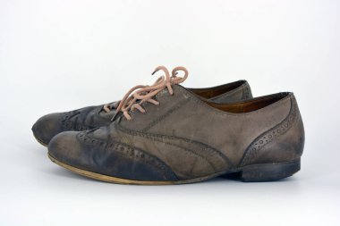 Beyaz arka planda dişi deri ayakkabılar var. Düz topuklu gri ayakkabı bağcıkları olan Oxford ayakkabıları. Gri kadın ayakkabıları, farkında olmadan bağlanıyor..