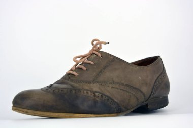 Beyaz arka planda dişi deri ayakkabılar var. Düz topuklu gri ayakkabı bağcıkları olan Oxford ayakkabıları. Gri kadın ayakkabıları, farkında olmadan bağlanıyor..