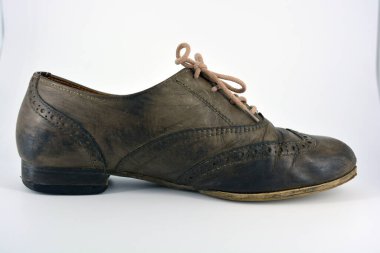 Beyaz arka planda dişi deri ayakkabılar var. Düz topuklu gri ayakkabı bağcıkları olan Oxford ayakkabıları. Gri kadın ayakkabıları, farkında olmadan bağlanıyor..