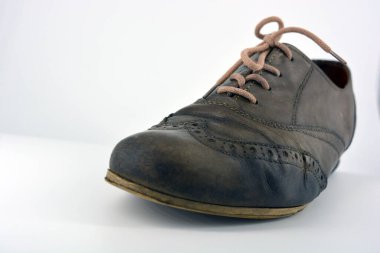 Beyaz arka planda dişi deri ayakkabılar var. Düz topuklu gri ayakkabı bağcıkları olan Oxford ayakkabıları. Gri kadın ayakkabıları, farkında olmadan bağlanıyor..