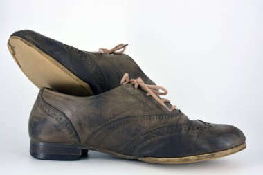 Beyaz arka planda dişi deri ayakkabılar var. Düz topuklu gri ayakkabı bağcıkları olan Oxford ayakkabıları. Gri kadın ayakkabıları, farkında olmadan bağlanıyor..