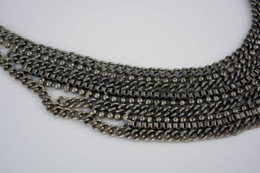 İlginç ve alışılmadık metalik, büyük bir süsleme, boynunda ilginç bir örgü bulunan beyaz bir kolye..