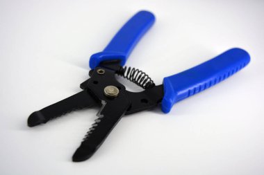 Beyaz plastik arka planda bulunan farklı çaplı kabloları budamak için mavi plastik saplı metal plasentler.