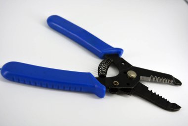 Beyaz plastik arka planda bulunan farklı çaplı kabloları budamak için mavi plastik saplı metal plasentler.