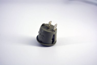 Beyaz plastik arka planda bulunan 220V veya 12V ağlarının değiştirilmesi ve eklenmesi için bağlantıları olan gri metal düğme.