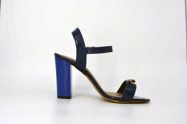 Bir şey daha, beyaz arka planda altın tabanlı geniş topuklu bir çift mavi lacquer sandalet..