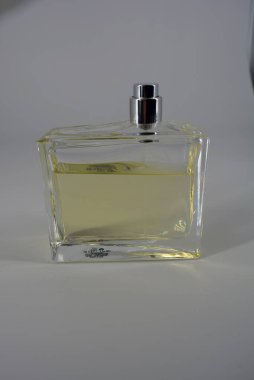 Güzel ve alışılmadık bir kadın parfümü şişesi. Beyaz arka planda sarı bir sıvı var.. 