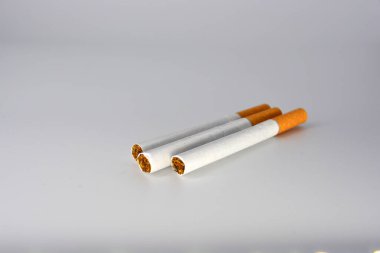 Beyaz arka planda kaotik kahverengi filtresi olan bir sürü beyaz sigara. Sigara içmek sağlığa zararlıdır. Sigara beyin sinirlerinin çalışmasını kötüleştirir.