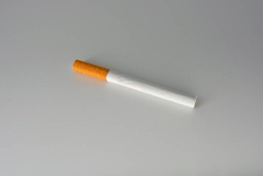 Beyaz arka planda kahverengi filtreli beyaz bir sigara. Sigara içmek sağlığa zararlıdır. Sigara beyin sinirlerinin çalışmasını kötüleştirir..