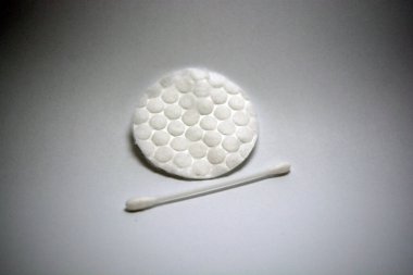 Kulakları temizlemek için pamuklu beyaz plastik çubuk ve beyaz arka planda bulunan yüzü temizlemek için pamuklu çubuk.. 