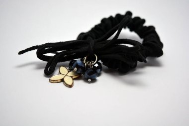 Kadın kumaşı siyah saç tokası, beyaz metalik çiçek ve siyah taşlarla süslü saç süsü.. 