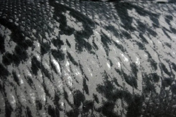 Unusual gray black animal print. Python background, snake fabric print. Interesting and peculiar structural spotted pattern.