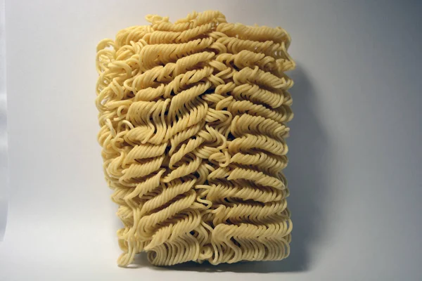 Anında vermicelli, beyaz bir arka planda ince, uzun vermicelli briketi. 