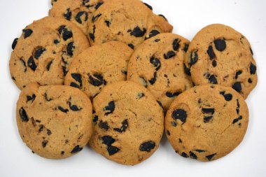 Beyaz arka planda çikolata parçalı büyük, lezzetli bir kurabiye.. 