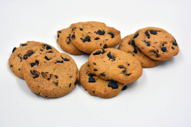 Beyaz arka planda çikolata parçalı büyük, lezzetli bir kurabiye.. 