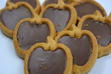 Lezzetli ve elma şekilli kurabiyeler. Beyaz arka planda kahverengi çikolatalı fındıklı.. 