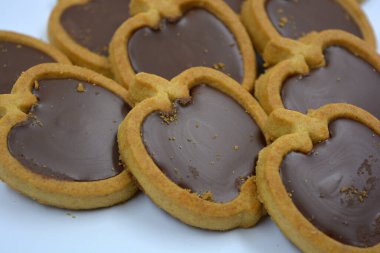 Lezzetli ve elma şekilli kurabiyeler. Beyaz arka planda kahverengi çikolatalı fındıklı.. 