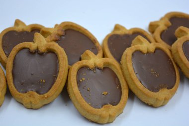 Lezzetli ve elma şekilli kurabiyeler. Beyaz arka planda kahverengi çikolatalı fındıklı.. 