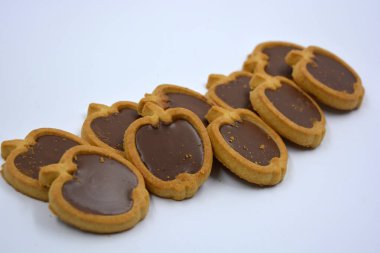 Lezzetli ve elma şekilli kurabiyeler. Beyaz arka planda kahverengi çikolatalı fındıklı.. 