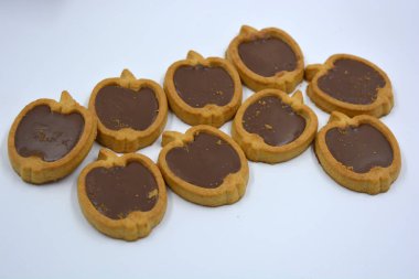 Lezzetli ve elma şekilli kurabiyeler. Beyaz arka planda kahverengi çikolatalı fındıklı.. 