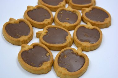 Lezzetli ve elma şekilli kurabiyeler. Beyaz arka planda kahverengi çikolatalı fındıklı.. 