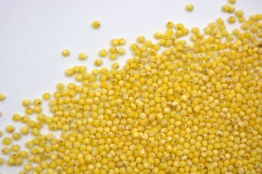 İnsan sağlığı tahılları için kullanışlı, beyaz arka plana saçılmış sarı darılar. 