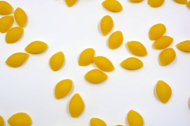 Kuru sarı İtalyan vermicelli, sert tahıl çeşitlerinden Wwkushi deniz kabukları tarafından yapılan makarna beyaz arka planda yer almaktadır.. 