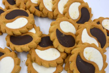 Güneş şeklinde beyaz ve çikolata dolgulu güvenlik bisküvisi. Beyaz arka planda iki damla şeklinde.. 