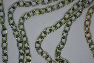 Beyaz arka planda kaotik bir şekilde taşmış olağandışı parlak metal zincirler..