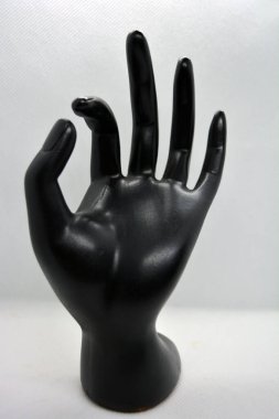 Kadın elinin siyah seramik heykeli, beyaz arka planda bulunan kadın bileği.. 