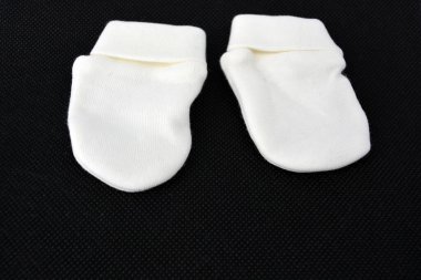 Çocuklar için beyaz pamuklu eldivenler ve çoraplar. Yüzü çizilmesin diye..