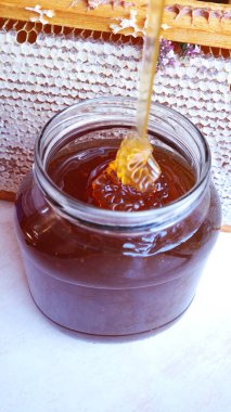 Arı balı kavanozu çerçevenin arka planında bal peteği ile