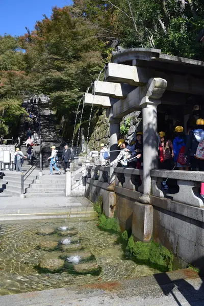 Turistas não identificados coletando água da cachoeira Otowa-no-taki no templo de Kiyomizu, Kyoto — Fotografia de Stock