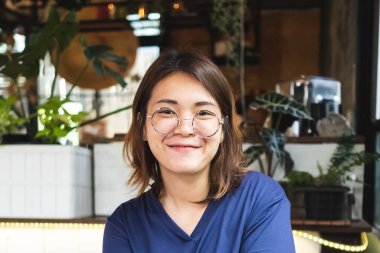 Genç Asyalı kadın kafede nar gazozu içiyor..