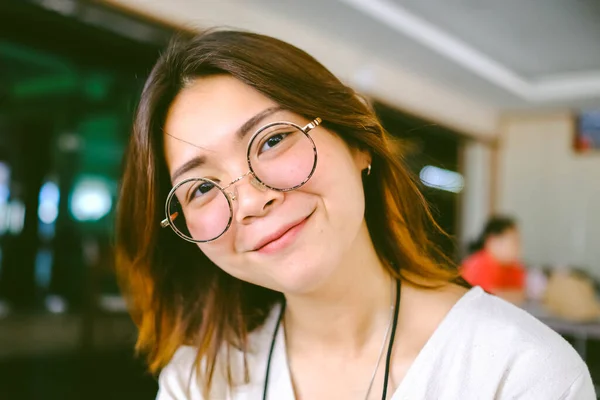 stock image Closeup of young Asian woman wears glasses with blur background.