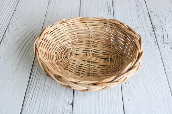 Empty weaved basket on the wooden table.