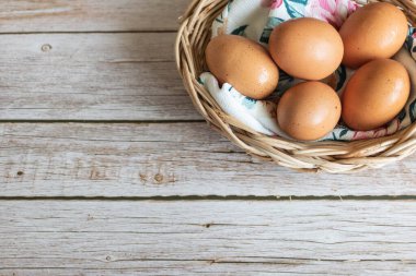 Kahverengi tavuk yumurtaları ahşap sepetin içinde, sevimli kumaşlı, yakın çekim manzaralı..