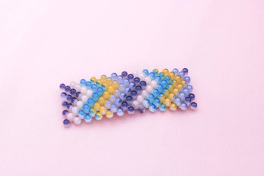 Pembe arka planda renkli saç tokası.