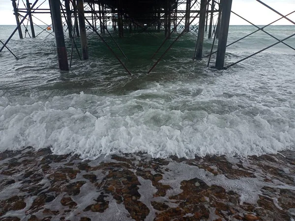 Frente Praia Com Cais Fundo Ondas Destroços Pedras Fundo Papel — Fotografia de Stock