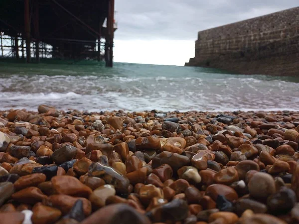Strand Mit Pier Hintergrund Und Wrackteile Wellen Steine Hintergrund Tapete — Stockfoto