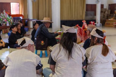Suphanburi, Tayland - 7 Kasım 2025: İnsanlar geleneksel bir Tayland Song Barajı cenaze törenine katılarak tören figürleri ve merhumun çerçeveli bir fotoğrafı ile ruh çağırma törenine katıldılar..