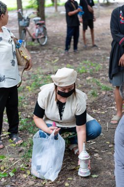 Suphanburi, Tayland - 7 Kasım 2025: Katılımcı, geleneksel Tayland Black Thai cenaze töreninde, kültürel saygı ve resmi anma töreninde yakma kemikleri düzenliyor.