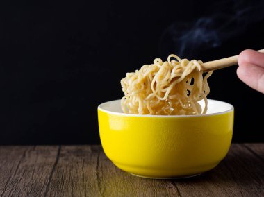 Kahvaltının resmi bir kase erişteli, çubuklu, dumanlı ya da buharlı. Asyalıların anlık yemeği. Restoranın hızlı pişirilmesi. Arka plan siyah..