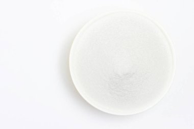 Resim, izole edilmiş şeker beyazı granüle kristalin üzerinde beyaz arka plandaki bir kasede, metin için fotokopi alanı olan mutfağı pişirmek için yatıyordu..