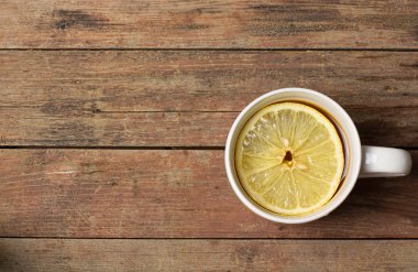 Ahşap arka plan üzerinde limonlu çay fincan