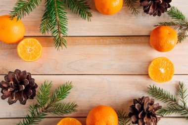 Noel dekoru. Tahta bir arka planda dallar, koniler ve mandallar.