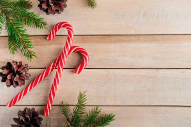 Tahta arka planda fidan dalları ve şekerler. Noel ve yeni yıl konsepti. Metin için yer.