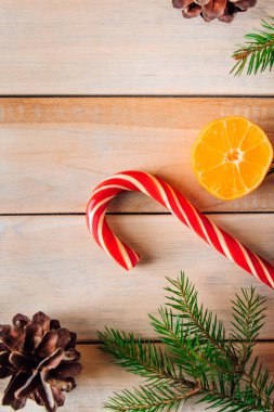 Noel ağacının dekoratif dalları, ahşap arka planda şekerler ve mandallar. Metin için yer.