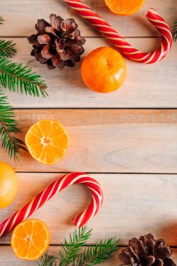 Noel ağacının dekoratif dalları, ahşap arka planda şekerler ve mandallar. Metin için yer.